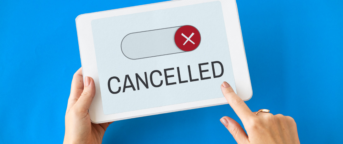 close em mãos usando um tablet que mostra na tela um botão de "cancelar"