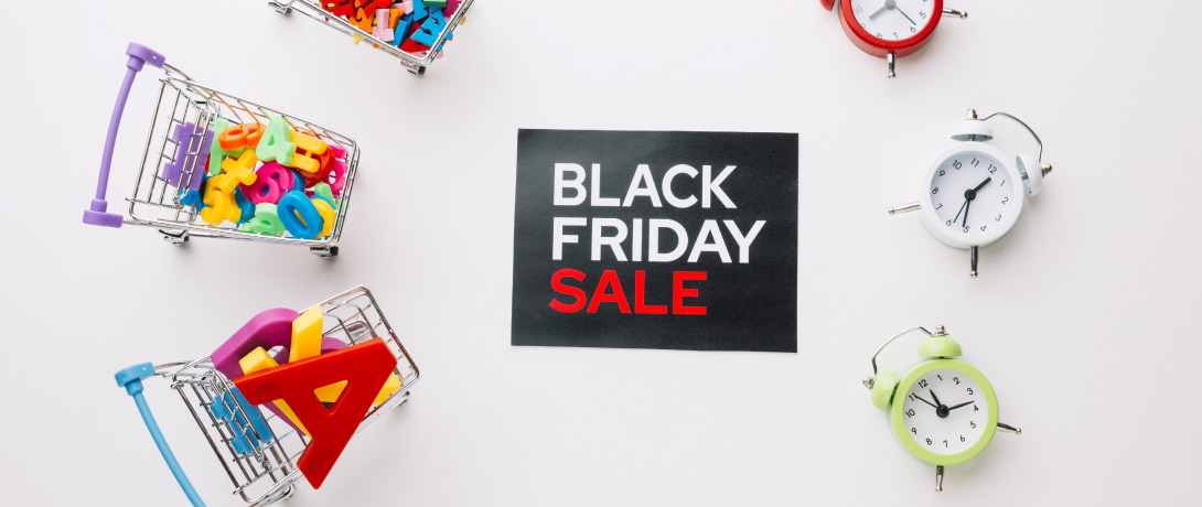 placa escrito "Black Friday" ao lado de um relógios e carrinhos de compras cheios