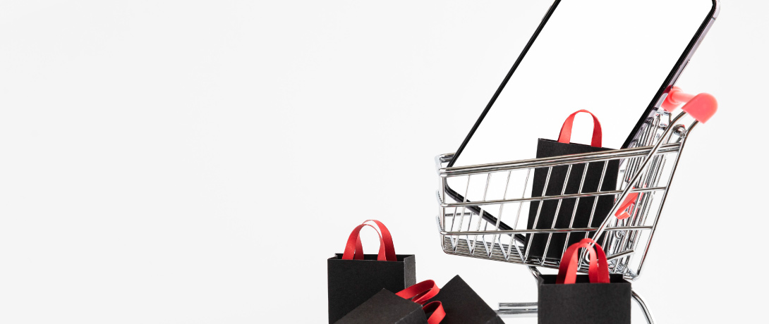 carrinho de compras com sacolas de compras e um celular dentro