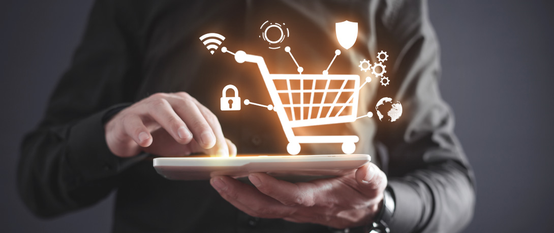 - close em uma pessoa usando um tablet, sobre a tela há uma ilustração de carrinho de compras