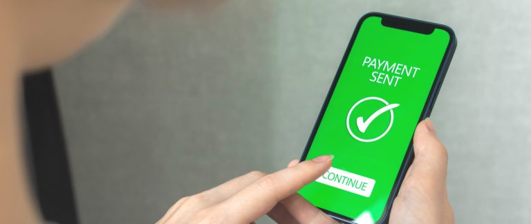 Mulher com as mãos usando o telefone celular para pagamento online.